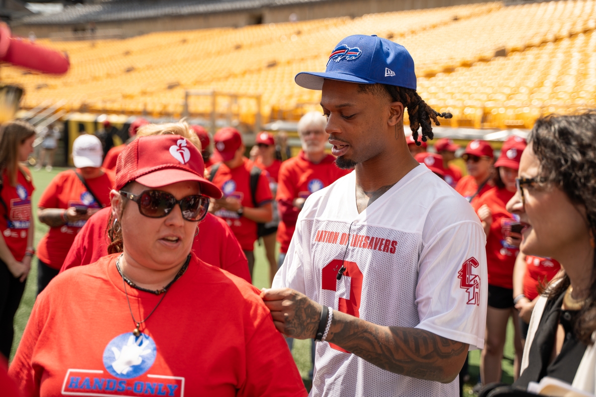 Damar Hamlin signs autographis at Nation of Lifesavers event at NFL Draft.