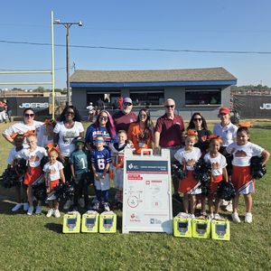 Youth football league poses with AED and Cardiac Emergency Response Plan map in North Texas