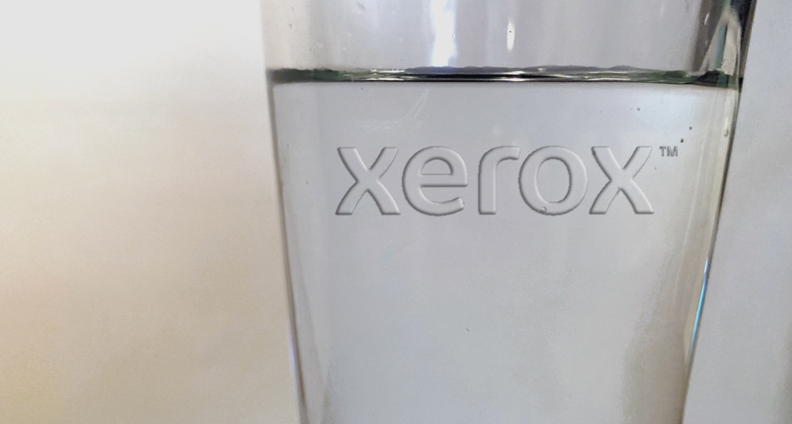 The Xerox logo appears in clear on a glass of water, symbolizing the Color of the Year 2020. The Xerox logo appears in clear on a glass of water, symbolizing the Color of the Year 2020.